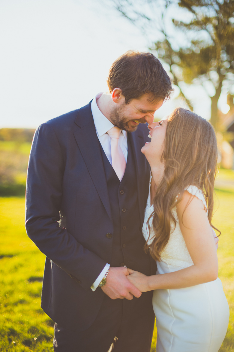 bride and groom laughing in the fields - alternative wedding photographer