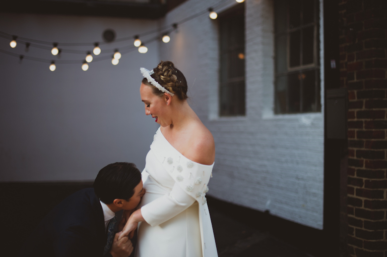 Groom kissing bride's bump at the Bistrotheque, East London Wedding