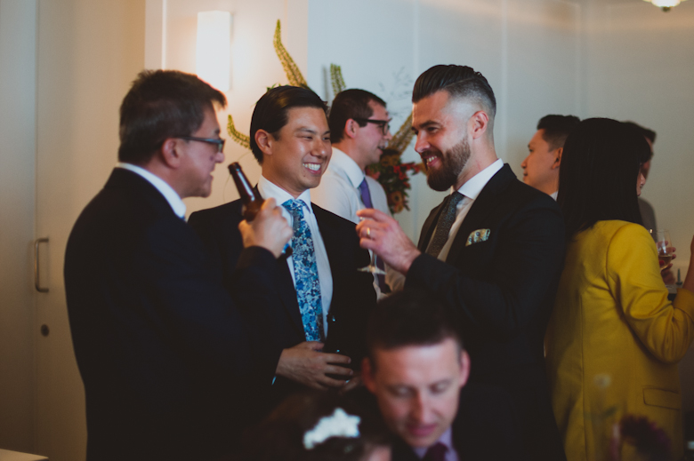 groom and friends laughing drinking