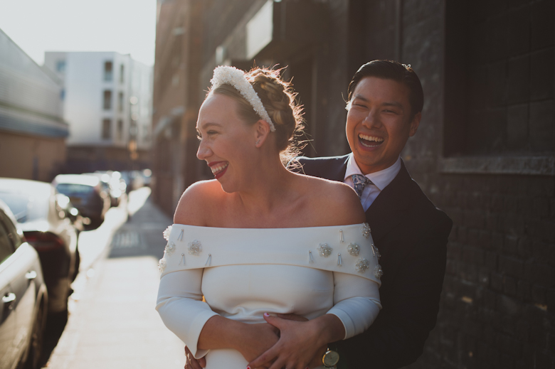 Bride and groom laughing outside the Bistrotheque, East London Wedding