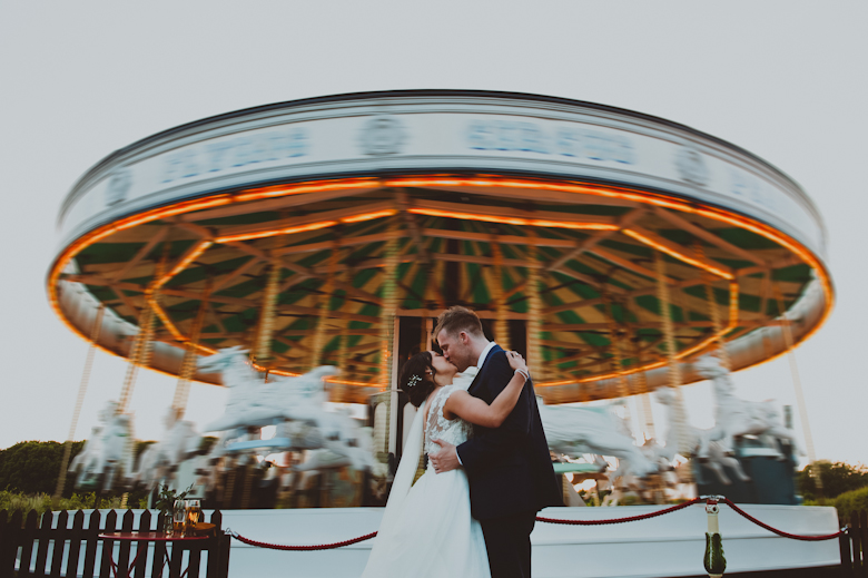 Preston Court Wedding - bride and groom kiss outside the carousel