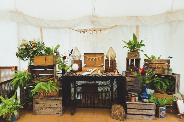 Surrey wedding photography - tipi wedding in Surrey - stylish retro rustic decor wooden boxes and green foliage 