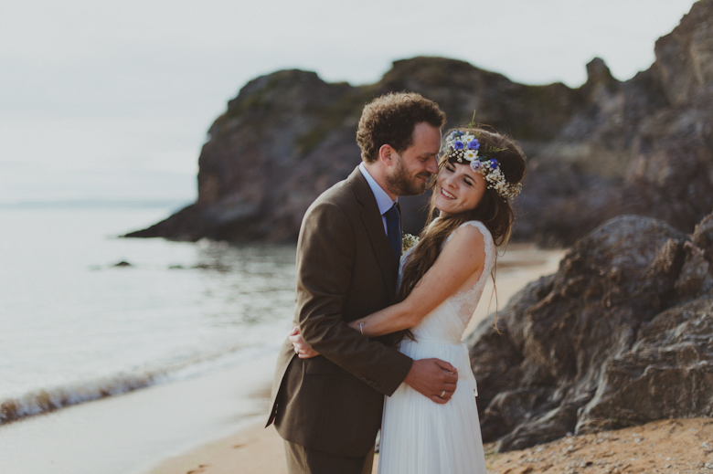 bride and groom on the beach - romantic shot, rocks and beautiful seaside landscape - Fun festival wedding